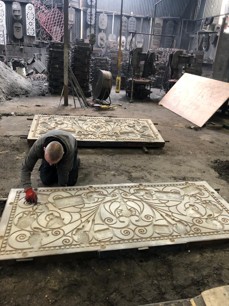 Foundry worker preparing a large sand mould used to cast decorative panels for The Golden Bandstand sculpture.